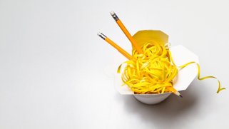 Pencils in a cup of ramen noodles.